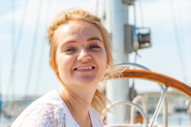 Arkadaşlar, bir yatın güvertesinde gülümseyen güzel ve neşeli kızlar