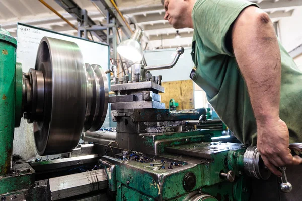 労働者 男は機械の金属製品を処理します 生産の回転仕事 — ストック写真