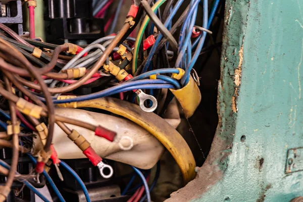 Old multicolored wires in the electrical cabinet of mechanical equipment