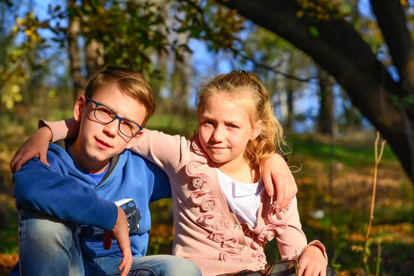 Garçon Avec Une Fille Sont Assis Sur Des Feuilles Sèches — Photo