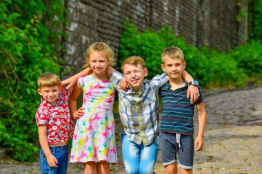Dört mutlu ve neşeli çocuklar birbirlerini kardeşlerim birlikte kucaklayan.
