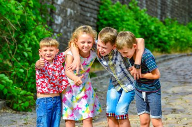 Dört mutlu ve neşeli çocuklar birbirlerini kardeşlerim birlikte kucaklayan.