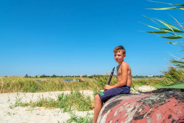 Chłopiec Bawi Się Czarny Klarnet Siedząc Starej Drewnianej Łodzi Plaży — Zdjęcie stockowe