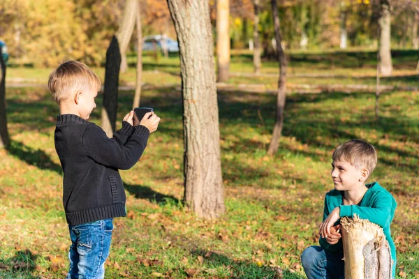 Ragazzo Scatta Foto Sullo Smartphone Suo Fratello Nel Parco Una — Foto Stock