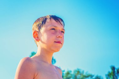 The boy after a swim on the beach, summer sunny day clipart