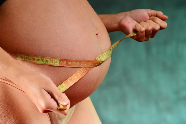 Zwanger Meisje Roze Slipje Een Blauwe Achtergrond Meet Omvang Van — Stockfoto
