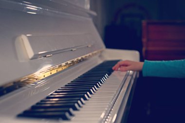 Piyano çalan bir melodi, beyaz tuşlar ellerinde. Kadınların elleri notlar melodi piyano klavye. Eller genç kızın, müzik piyano