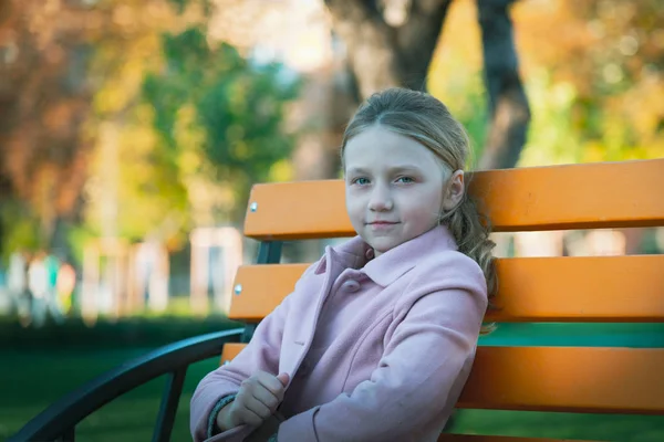 Una Chica Con Abrigo Rosa Está Sentada Banco Amarillo Parque — Foto de Stock