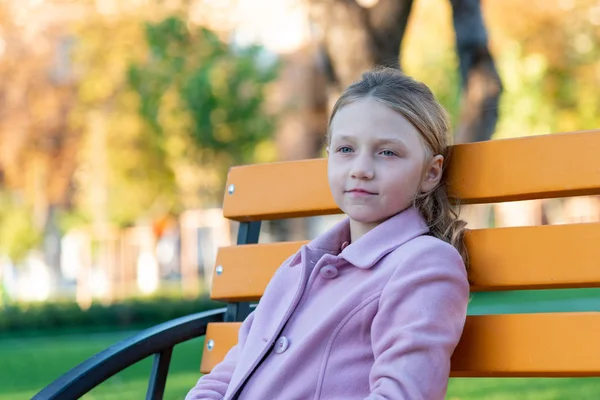 Une Fille Manteau Rose Est Assise Sur Banc Jaune Dans — Photo