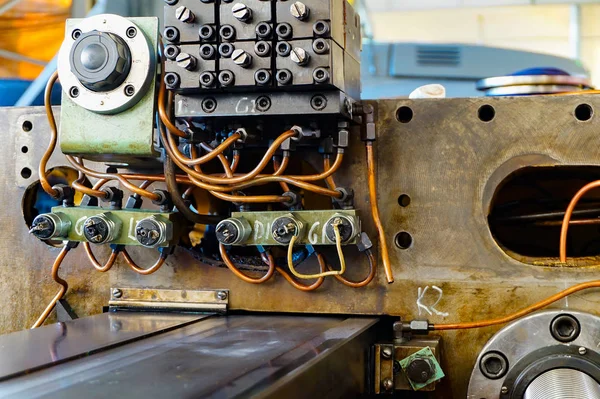 The hydraulic system on the machine, copper oil tubes connected to the equipment in production. Bed for guides under the influence of the hydraulic system. Abstract industrial background