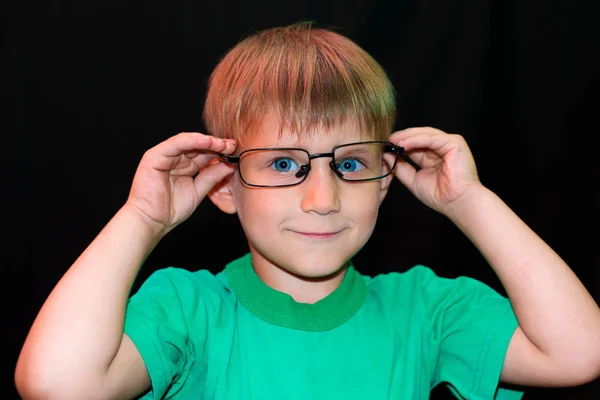 Gözlük Rahat Çocuk Kameraya Farklı Yüzleri Karanlık Bir Arka Plan — Stok fotoğraf