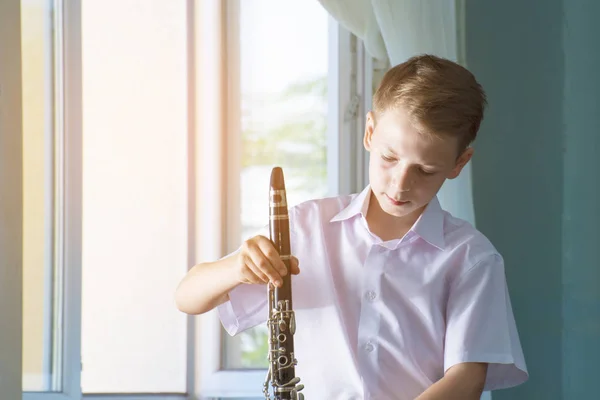Ένα Αγόρι Ένα Κλαρινέτο Παίζει Μουσική Κοντά Στο Παράθυρο — Φωτογραφία Αρχείου