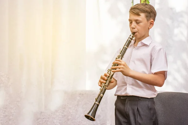 Rapaz Com Clarinete Toca Música Perto Janela — Fotografia de Stock