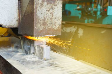 Soğutma suyu ile düz bir makine araç üzerinde metal taşlama. Metal işleme endüstrisi. Renk tonu ile resim.