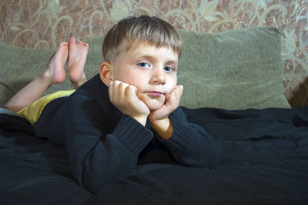 Niño Está Tumbado Sofá Mira Cámara —  Fotos de Stock