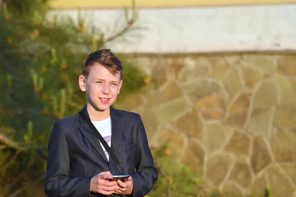 Chłopiec Smartphone Odczytuje Wiadomości Smartphone Patrzy Kamerę — Zdjęcie stockowe