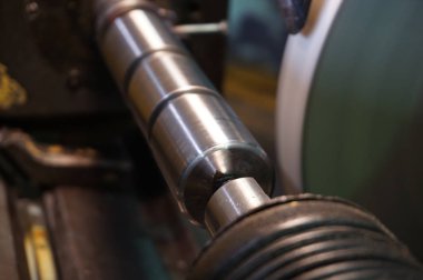 Bir kıvılcım ile üretimde dairesel bir taşlama makinesinde mili işleme