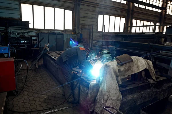 Welder at work when processing metal in production. Sparks in the welding of steel.