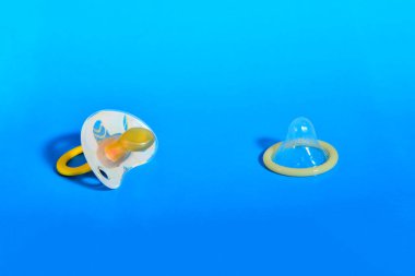 Bebek meme ve prezervatif üzerinde mavi arka plan, sağlıklı cinsel kavramı ve çocuk doğum