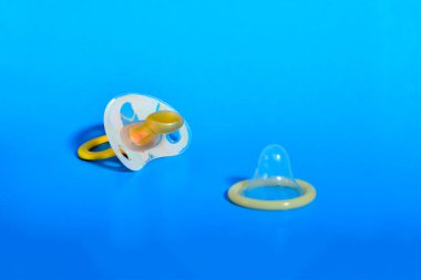 Bebek meme ve prezervatif üzerinde mavi arka plan, sağlıklı cinsel kavramı ve çocuk doğum