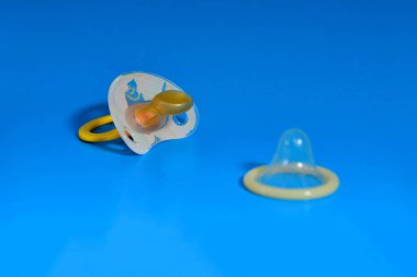 Bebek meme ve prezervatif üzerinde mavi arka plan, sağlıklı cinsel kavramı ve çocuk doğum