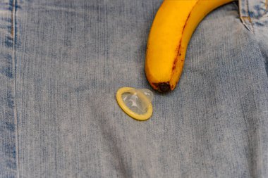 Kot pantolon sarı muz şeklinde dan çıkıntılı bir prezervatif ile dik bir penis taklit