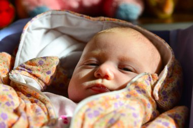 Yeni doğmuş bir bebek yatıyor ve bir bebek arabası çocuk yumuşak oyuncaklar çerçevede arar