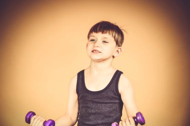 Çocuk için spor dumbbells, genç bir gövde üzerinde fiziksel zorlama ile gider