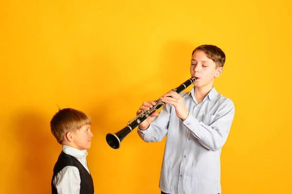 Il ragazzo insegna al fratello minore a suonare il clarinetto — Foto Stock