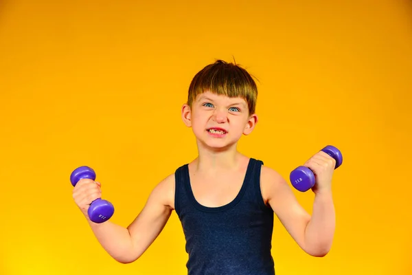O menino está envolvido em musculação, esportes em uma idade jovem, halterofilismo da criança — Fotografia de Stock