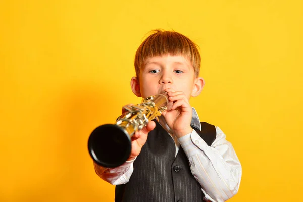 Um rapazinho de fato toca clarinete. — Fotografia de Stock