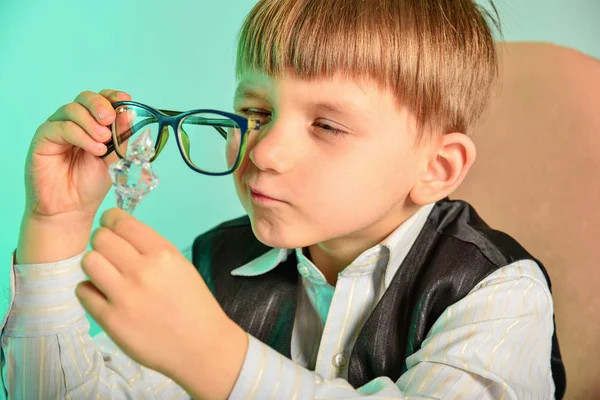 Дитина вивчає камінь через окуляри, концепцію дітей, бізнес, ювелірні вироби — стокове фото