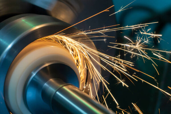 Internal processing of the hole with an abrasive stone on a grinding machine, sparks fly in different directions.