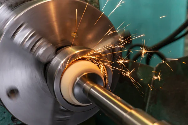 Processamento interno do buraco com uma pedra abrasiva em uma máquina de moagem, faíscas voam em direções diferentes . — Fotografia de Stock