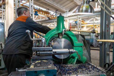 Turner çalışan bir Torna üzerinde mekanik kesme metal işleme sürecini yönetir.
