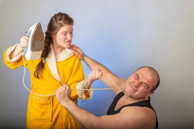 A wife in a yellow robe beats a bald husband, the concept of a family quarrel. clipart