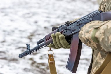 Kış eldivenleri bir Kalaşnikof saldırı tüfeği ile asker, aşağı varil ile bir silah tutan, savaş ve savaş sonu kavramı.