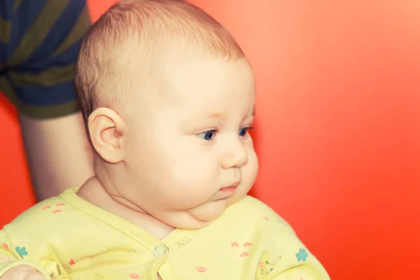 Портрет новорожденного ребенка на красном фоне в студии — стоковое фото