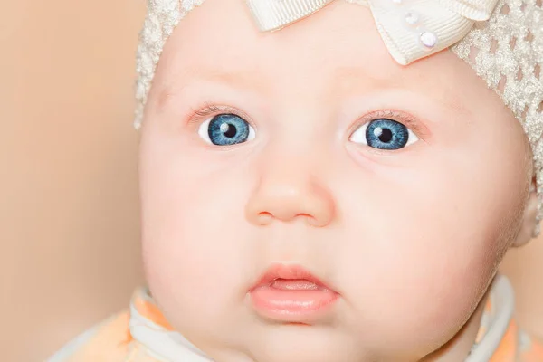 Newborn baby girl with a bandage on his head and blue eyes, close-up. — Stock Photo, Image