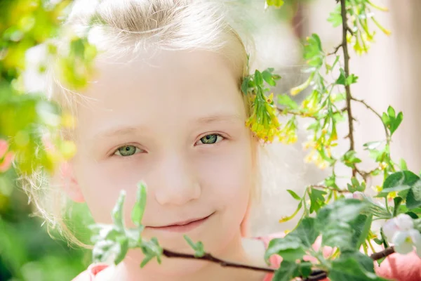 Retrato de una niña en el parque sobre el fondo de hojas y ramas naturales — Foto de Stock