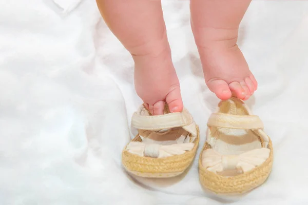 Sapatos para um bebê recém-nascido, botas de bebê no fundo de pequenas pernas . — Fotografia de Stock