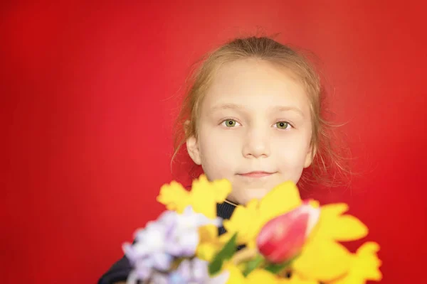 Portrait d'une fille avec des fleurs sur fond rouge en studio close-up . — Photo