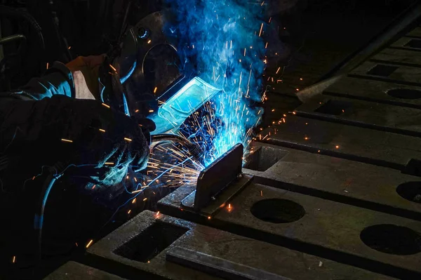 Рабочий сварщик выполняет сварочные работы в производстве с использованием электродуговой металлической сварки . — стоковое фото