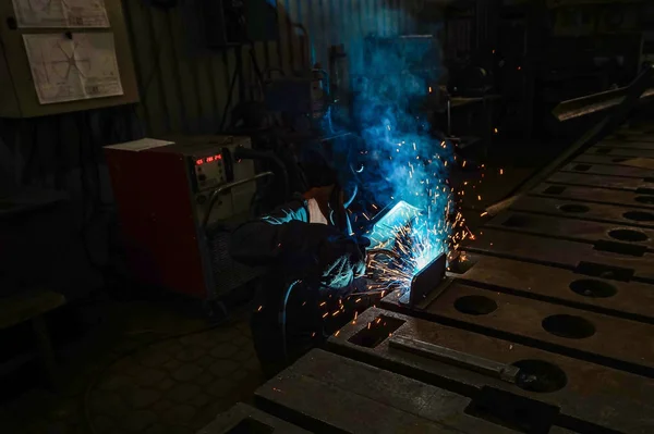工作焊工使用电弧金属焊接进行生产中的焊接工作. — 图库照片