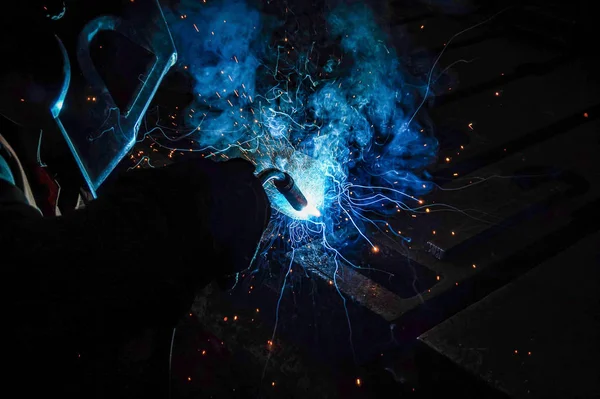 O soldador de trabalho executa o trabalho de soldagem na produção usando soldagem de metal de arco elétrico . — Fotografia de Stock