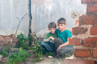 Terk edilmiş bir evde çocuklar, iki yoksul terk edilmiş çocuk, doğal afetler ve askeri eylemler sonucu yetim. Gönderim fotoğrafı.
