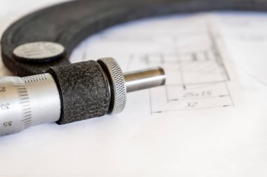Mikrometre teknik çizim üzerinde, teknik süreç tamamlandıktan sonra yatıyor.