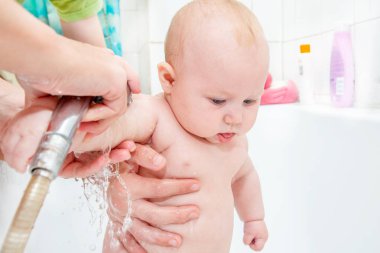 Duşta küçük bir çocuk, yeni doğmuş bir kız banyo, bir çocuk için su prosedürleri; temiz hijyen ve Çocuk Bakımı.