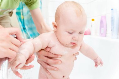 Duşta küçük bir çocuk, yeni doğmuş bir kız banyo, bir çocuk için su prosedürleri; temiz hijyen ve Çocuk Bakımı.