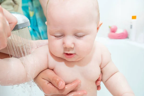 Маленький ребенок в душе, купание новорожденной девочки, водные процедуры для ребенка; чистая гигиена и уход за ребенком . — стоковое фото
